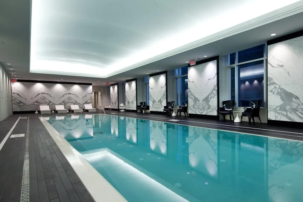 custom wall murals and backlit stretch ceiling in hotel swimming pool area