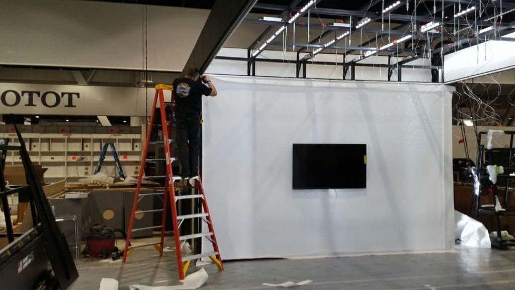 laqfiol team preparing Cambria exhibition with stretching wall cover